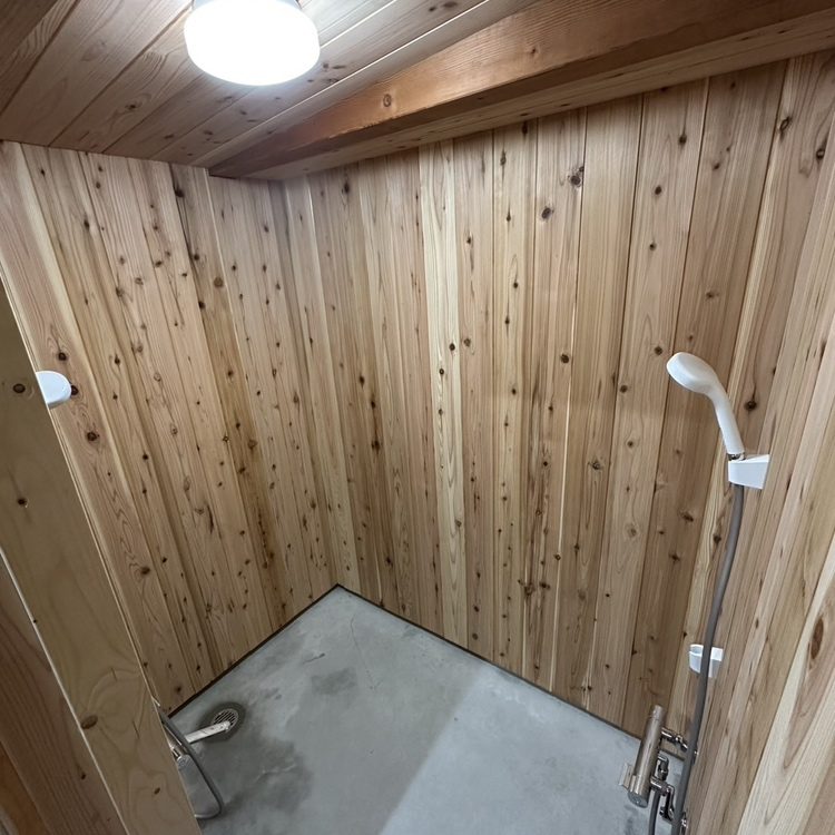 新しく建てられた、木の板張りのシャワー室